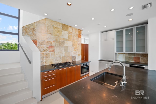 7276 Kiva Way, Gulf Shores, AL 36542 - kitchen with a sink, appliances with stainless steel finishes, backsplash, recessed lighting, and glass insert cabinets