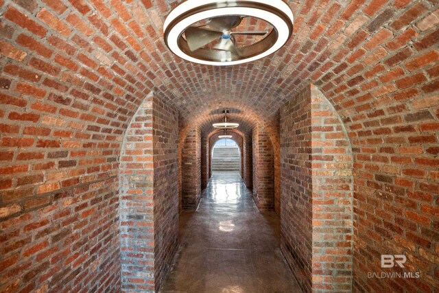 7276 Kiva Way, Gulf Shores, AL 36542 - hall with brick ceiling, brick wall, and lofted ceiling
