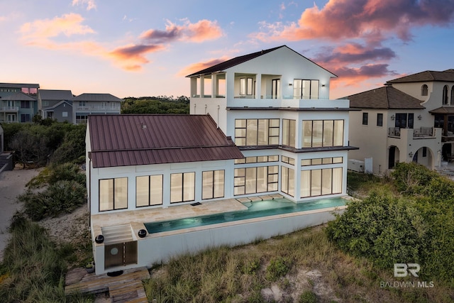 7276 Kiva Way, Gulf Shores, AL 36542 - rear view of house with a balcony, stucco siding, metal roof, and a standing seam roof