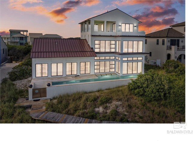 7276 Kiva Way, Gulf Shores, AL 36542 - back of property with a balcony, stucco siding, a standing seam roof, and metal roof