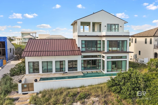 7276 Kiva Way, Gulf Shores, AL 36542 - rear view of house featuring a balcony, a standing seam roof, stucco siding, and metal roof