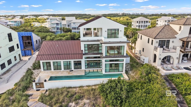 7276 Kiva Way, Gulf Shores, AL 36542 - rear view of property featuring a balcony, a residential view, a standing seam roof, and a patio area