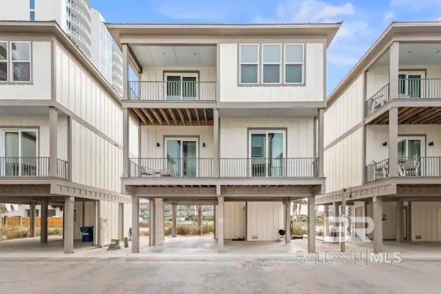 rear view of property featuring a balcony and a carport