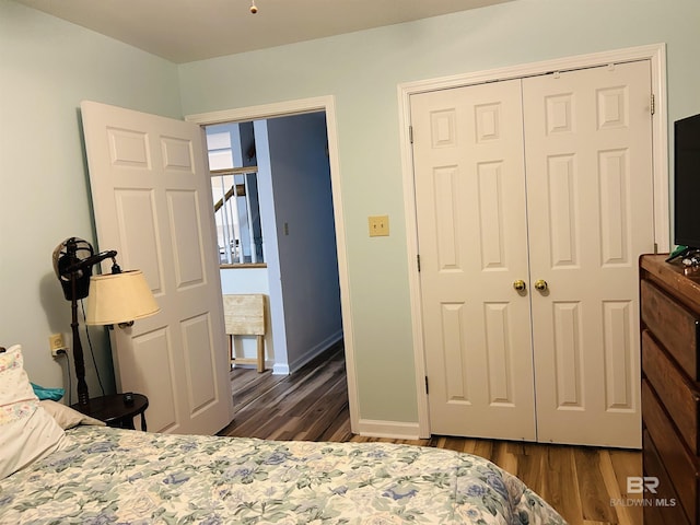 bedroom featuring wood finished floors, a closet, and baseboards
