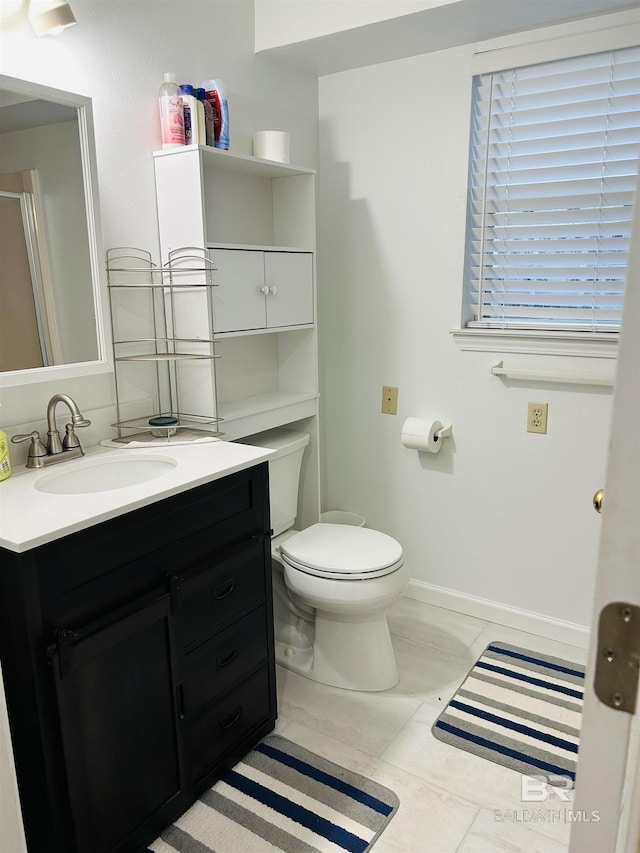 bathroom featuring toilet, vanity, and a shower with shower door
