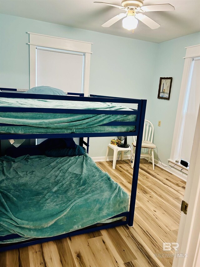 bedroom with wood finished floors, ceiling fan, and baseboards
