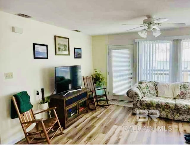 living area with a ceiling fan and wood finished floors