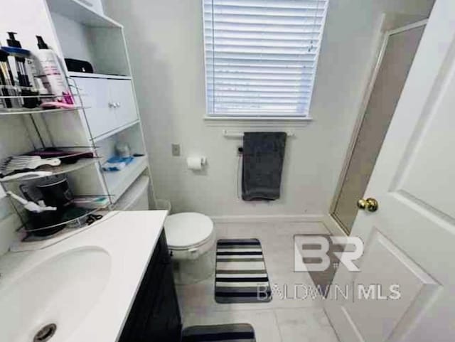 bathroom featuring tile patterned flooring, a shower stall, vanity, and toilet