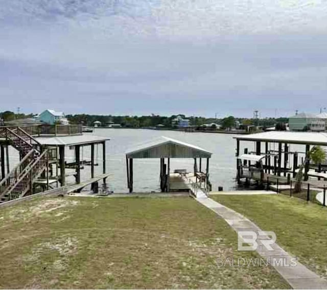 dock with boat lift, a water view, and a lawn