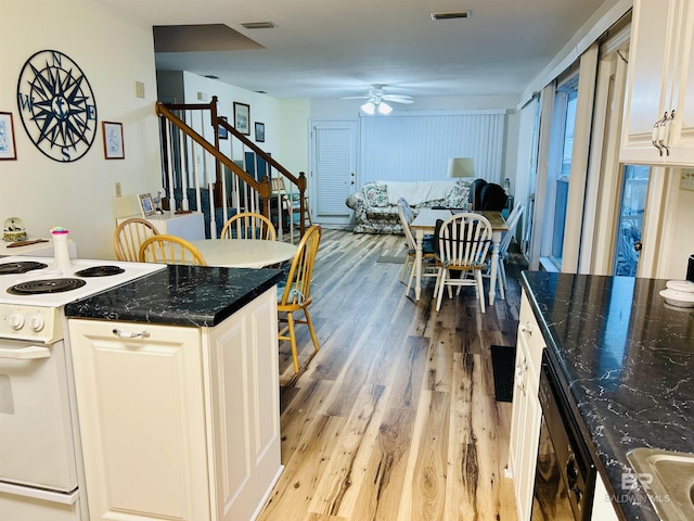 kitchen with white electric range oven, a ceiling fan, light wood-style floors, black dishwasher, and white cabinetry