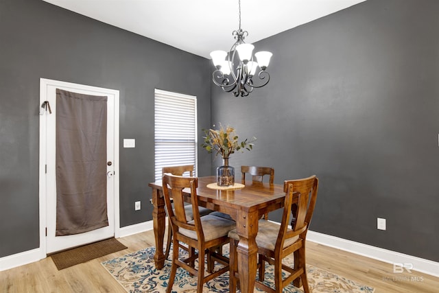 dining room with light hardwood / wood-style floors and a chandelier