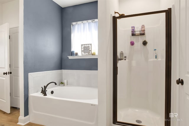 bathroom featuring shower with separate bathtub and wood-type flooring