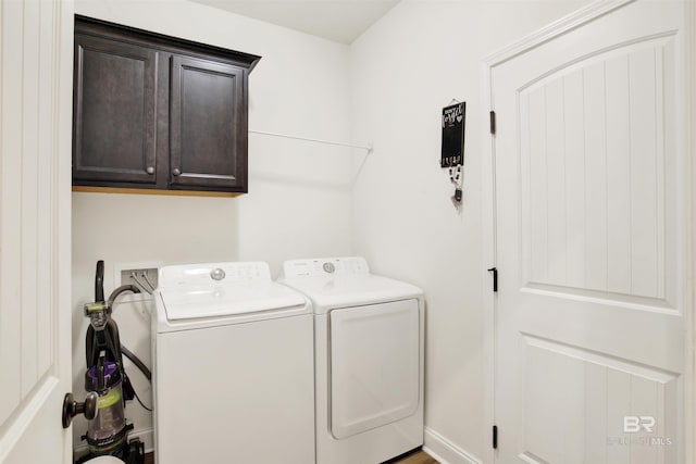 laundry room with washing machine and dryer and cabinets