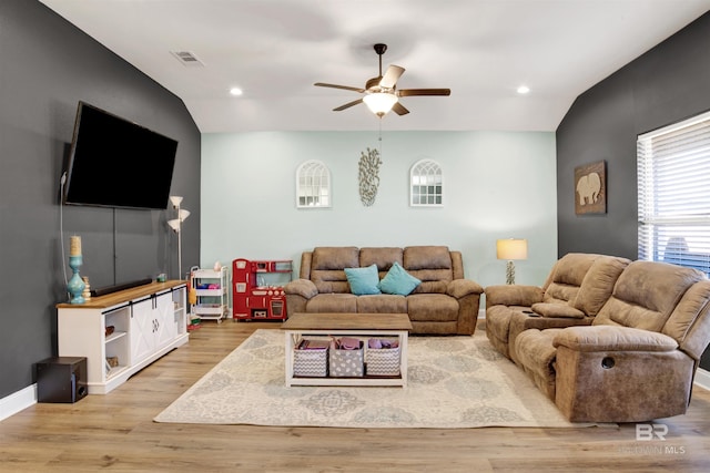 living room with lofted ceiling, light wood-type flooring, and ceiling fan