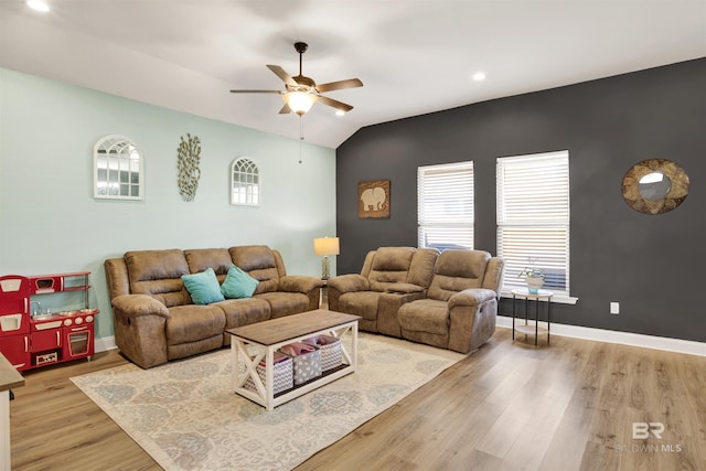 living room featuring lofted ceiling, ceiling fan, and light hardwood / wood-style flooring