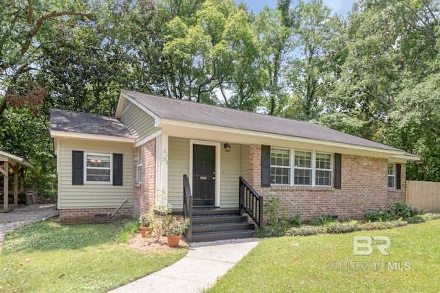 2105 Upham Pl, Mobile, AL 36607 - view of front of house with a front yard, brick siding, a shingled roof, and crawl space