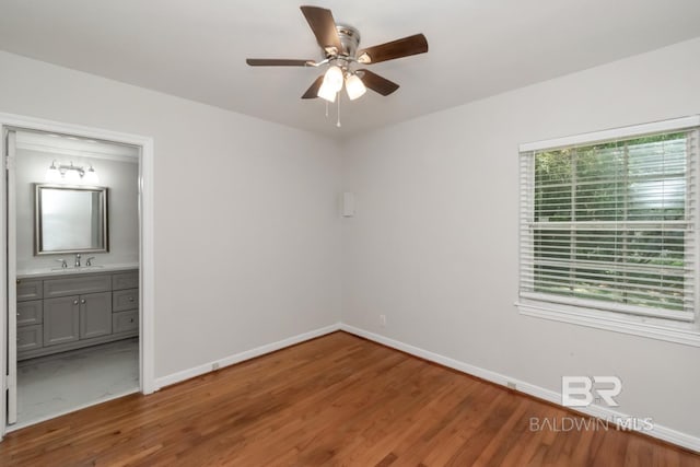 2105 Upham Pl, Mobile, AL 36607 - unfurnished bedroom featuring wood finished floors, a sink, baseboards, and ensuite bathroom