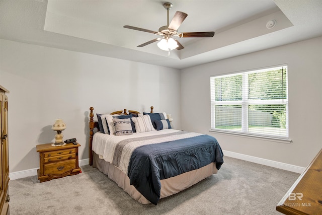 22894 Ridgewood Dr, Robertsdale, AL 36567 - bedroom with a tray ceiling, light colored carpet, baseboards, and ceiling fan