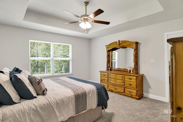 22894 Ridgewood Dr, Robertsdale, AL 36567 - bedroom featuring a raised ceiling, light colored carpet, baseboards, and ceiling fan