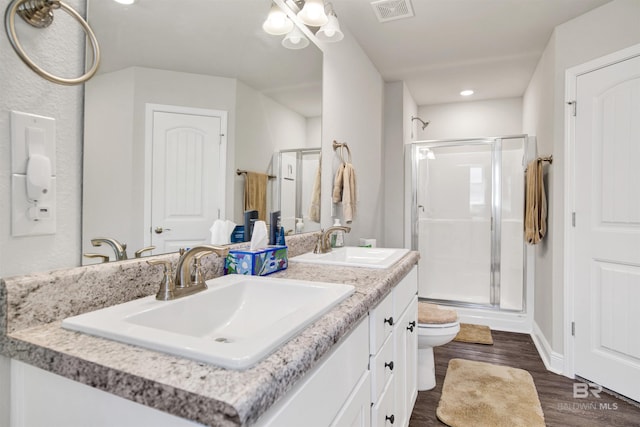 22894 Ridgewood Dr, Robertsdale, AL 36567 - bathroom featuring a shower stall, toilet, double vanity, wood finished floors, and recessed lighting