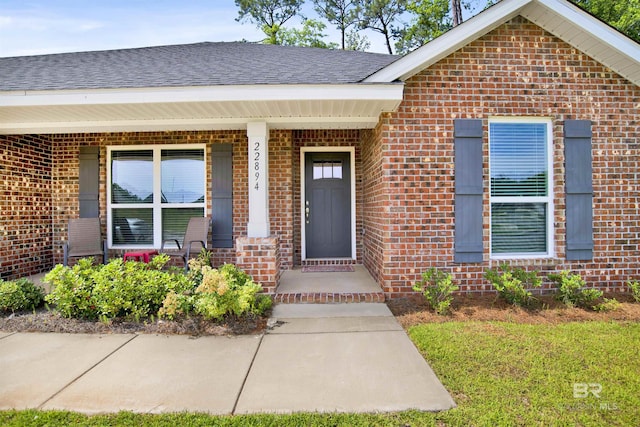 22894 Ridgewood Dr, Robertsdale, AL 36567 - doorway to property with brick siding, roof with shingles, and a porch