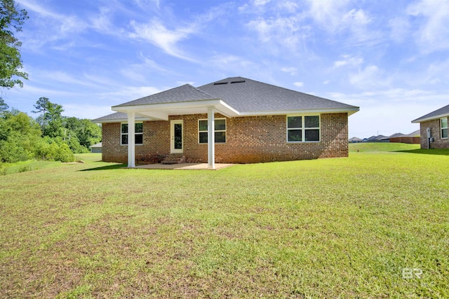 22894 Ridgewood Dr, Robertsdale, AL 36567 - back of property with a patio area, a lawn, brick siding, and roof with shingles