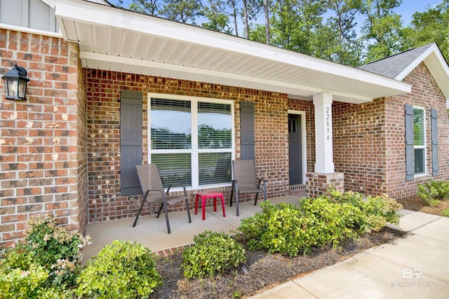 22894 Ridgewood Dr, Robertsdale, AL 36567 - view of exterior entry with brick siding and a porch