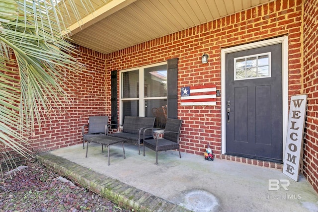 property entrance with covered porch and brick siding