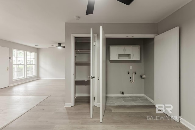 clothes washing area with ceiling fan, cabinets, light hardwood / wood-style floors, and washer hookup