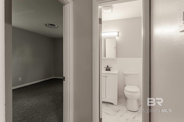 bathroom with vanity, tile walls, and toilet