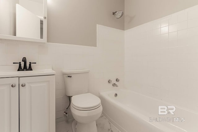 bathroom with vanity, a bath, toilet, and tile walls