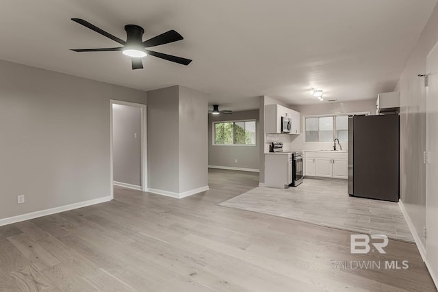 interior space featuring ceiling fan, sink, and light hardwood / wood-style floors