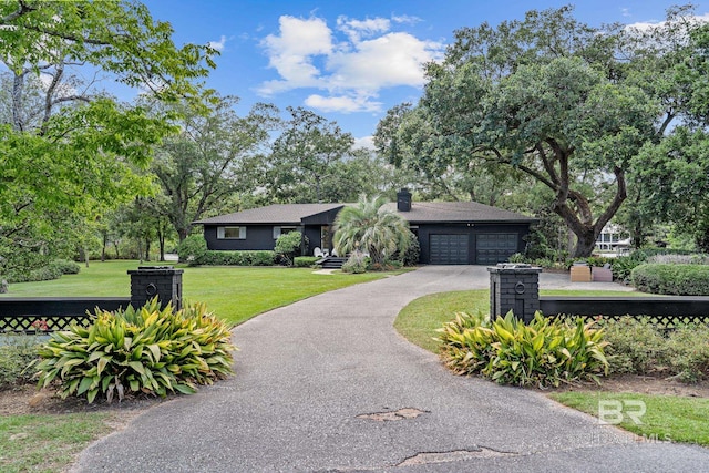 ranch-style home with a garage and a front lawn