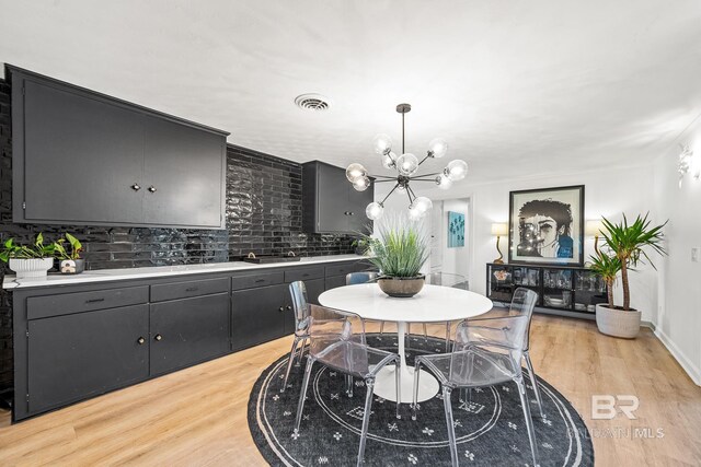 dining area with a chandelier and light hardwood / wood-style flooring