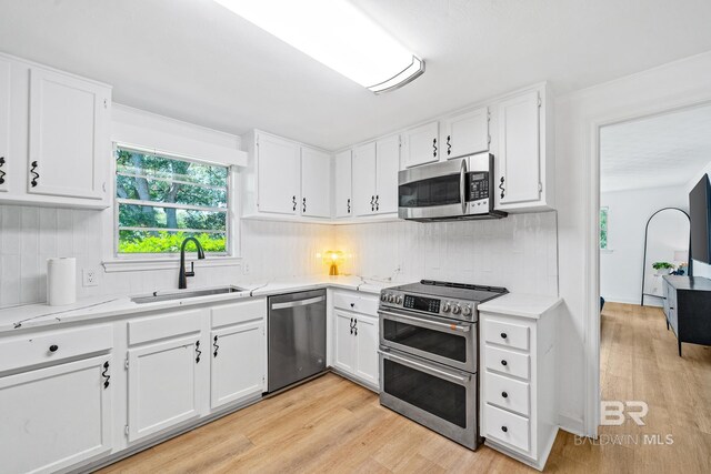 kitchen featuring white cabinets, light hardwood / wood-style flooring, and appliances with stainless steel finishes