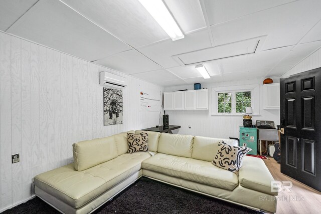 living room featuring a wall mounted air conditioner and hardwood / wood-style floors