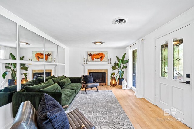 living room featuring a tile fireplace and light hardwood / wood-style floors