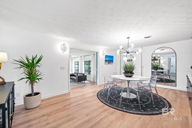 dining space featuring light hardwood / wood-style floors and a chandelier