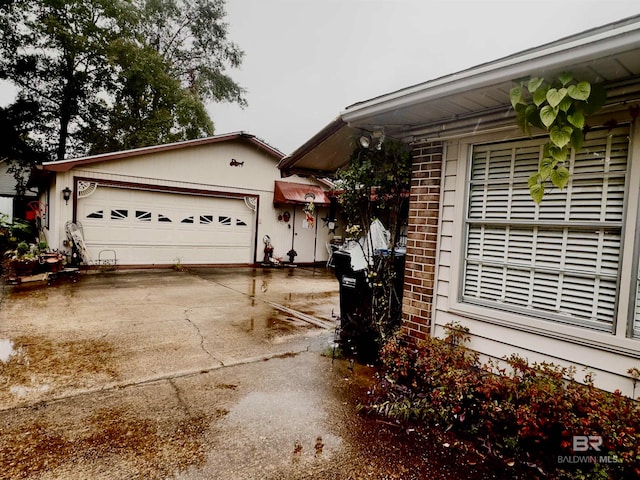 view of side of home featuring brick siding and an attached garage