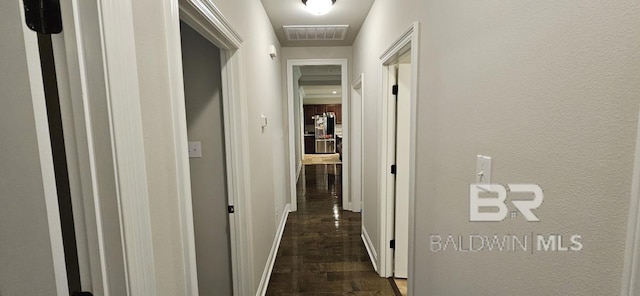 corridor with dark hardwood / wood-style flooring