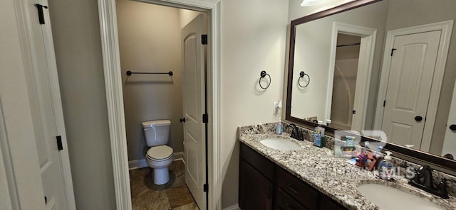 bathroom with dual vanity, toilet, and tile patterned floors