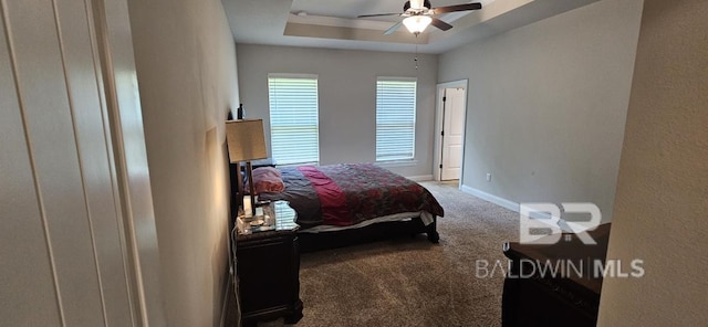 bedroom with ceiling fan, carpet flooring, and a raised ceiling