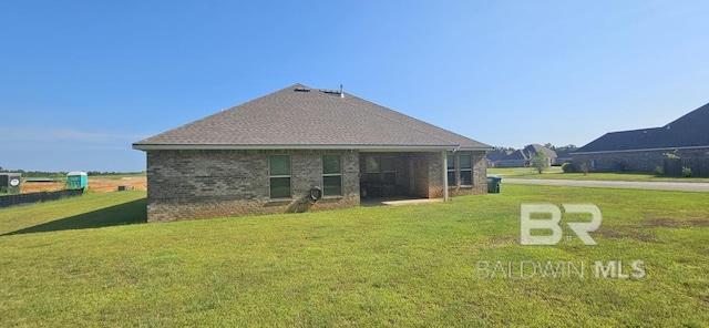 rear view of house featuring a yard