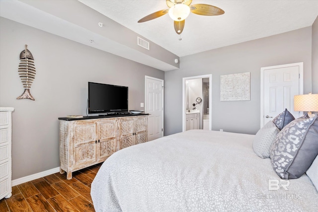 bedroom featuring dark wood-style floors, visible vents, ensuite bathroom, ceiling fan, and baseboards