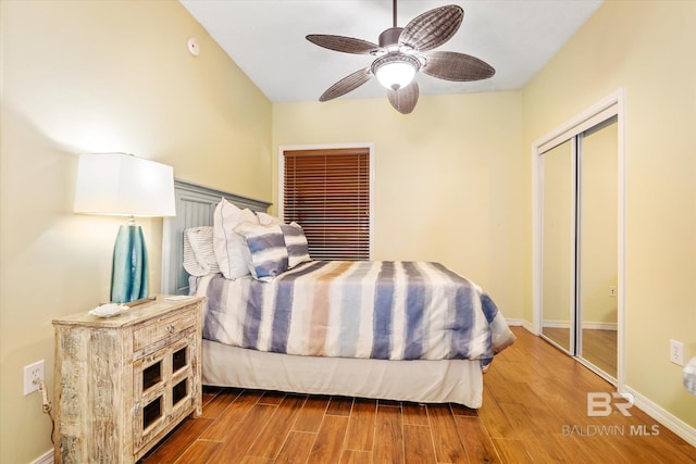 bedroom featuring a closet, ceiling fan, baseboards, and wood finished floors