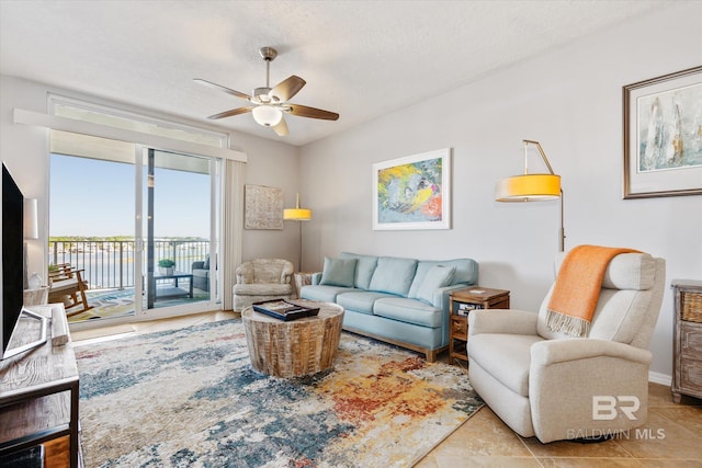 tiled living room featuring ceiling fan and a textured ceiling