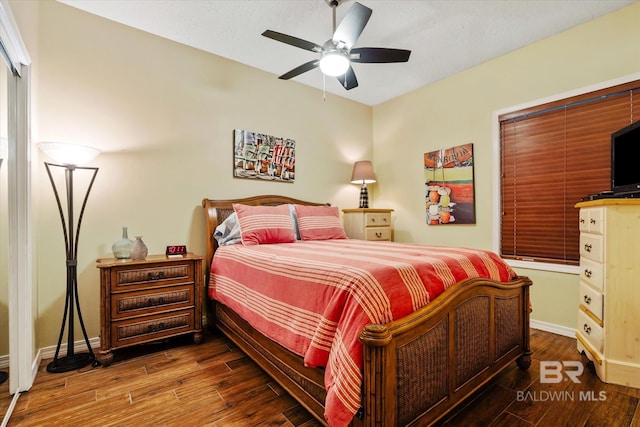 bedroom with ceiling fan, baseboards, and wood finished floors