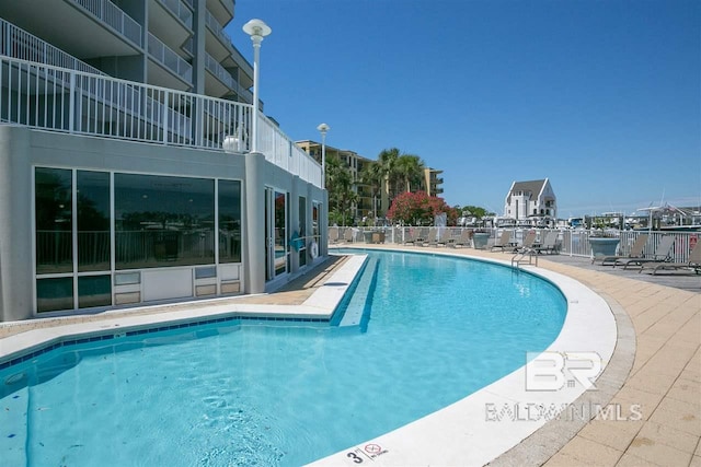 community pool featuring a patio area and fence