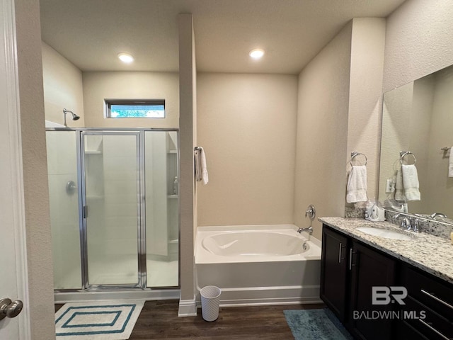 bathroom with vanity, wood-type flooring, and independent shower and bath