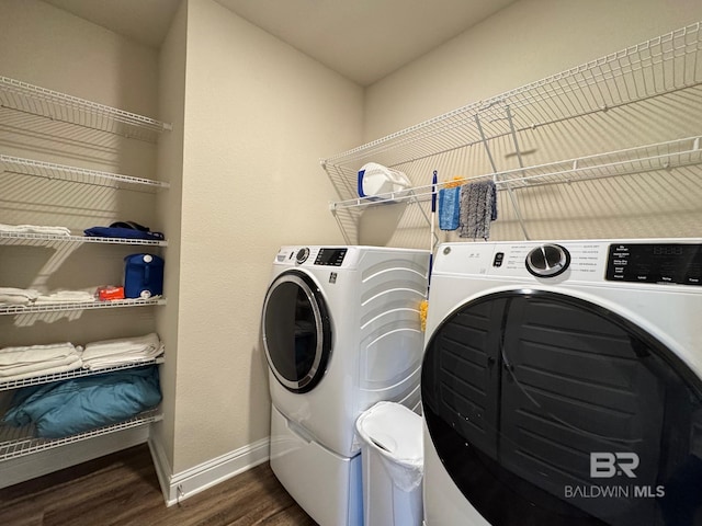 clothes washing area with dark hardwood / wood-style floors and separate washer and dryer